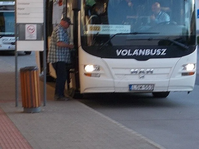 Utasok beszállása a menetrend szerinti járatra a peronon
